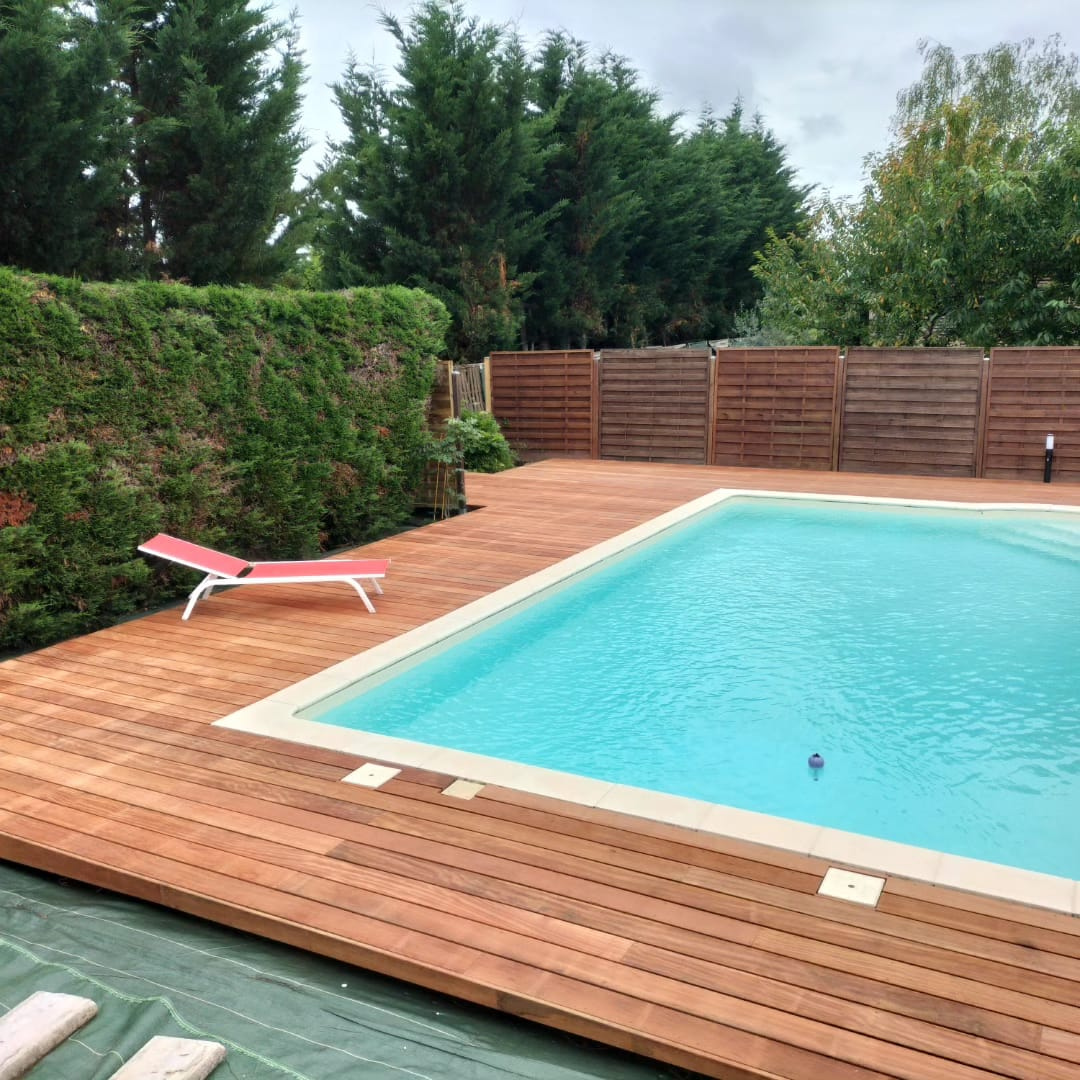 Pose de lames de terrasse en bois dans un jardin périgourdin